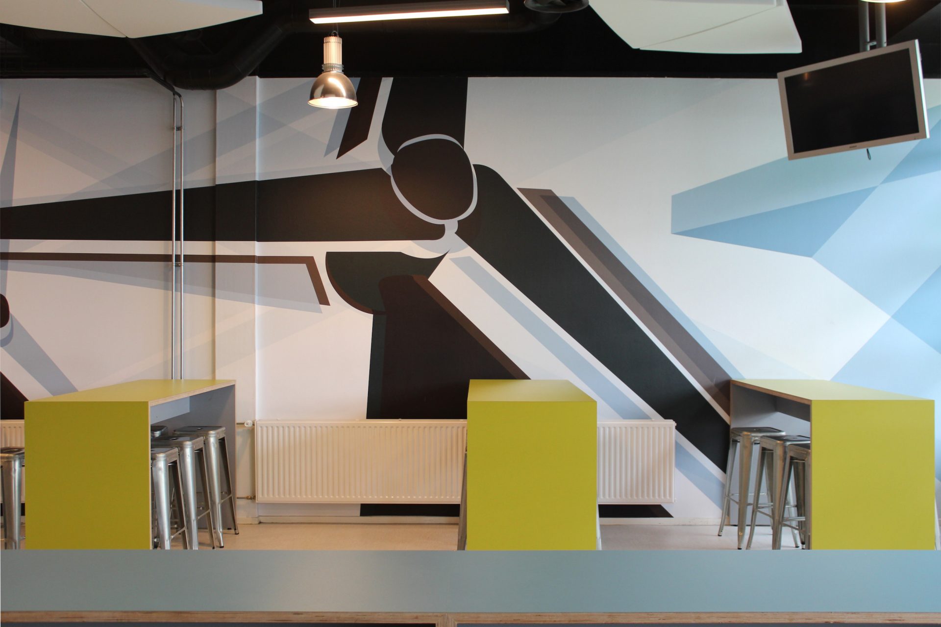 Grote diapositieve prints van windmolens geïnspireerd op Andy Warhol op de muur van de centrale hal in ROC Friese Poort in deze projectinrichting.